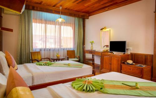 a hotel room with two beds and a television at Ta Prohm Hotel & Spa in Siem Reap