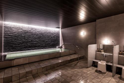 a bathroom with a bath tub and a toilet at New Tomakomai Prince Hotel NAGOMI in Tomakomai