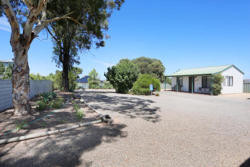 a driveway with a tree and a house at Moonta Bay Accommodation in Port Moonta