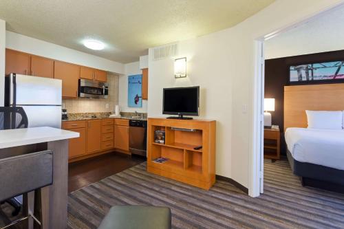 a hotel room with a bed and a kitchen at Hyatt House Houston Galleria in Houston