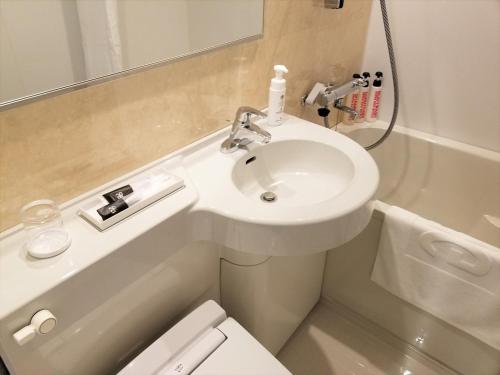 a bathroom with a sink and a toilet and a shower at Green Rich Hotel & Capsule Naha - Artificial hot spring Futamata Yunohana in Naha