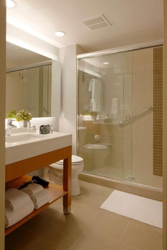 a bathroom with a shower and a sink and a toilet at Hyatt Place Pensacola Airport in Pensacola