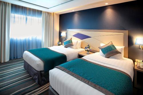 a hotel room with two beds and a window at Al Sarab Hotel in Dubai