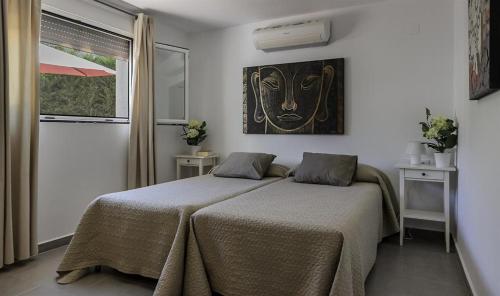Un dormitorio con una cama y un cuadro en la pared. en Andrago, en Moraira