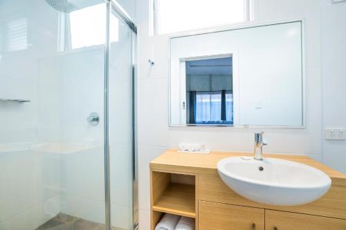 uma casa de banho com um lavatório e um chuveiro em Downs Motel em Toowoomba