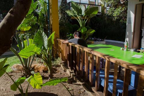 a man sitting at a table in a garden at Rossco Hostel & Hotel in San Cristóbal de Las Casas