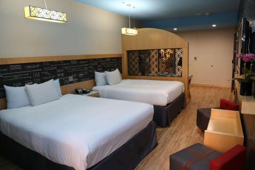 a hotel room with two beds and a chair at TRYP by Wyndham New York City Times Square - Midtown in New York