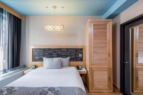 a bedroom with a white bed and a window at TRYP by Wyndham New York City Times Square - Midtown in New York