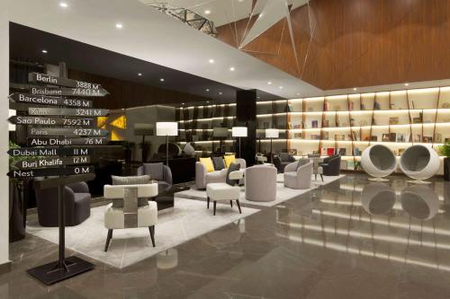 a waiting room with white chairs and tables and signs at TRYP by Wyndham Dubai in Dubai