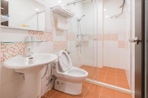 a bathroom with a toilet and a sink and a shower at Rhino Guest House in Hualien City