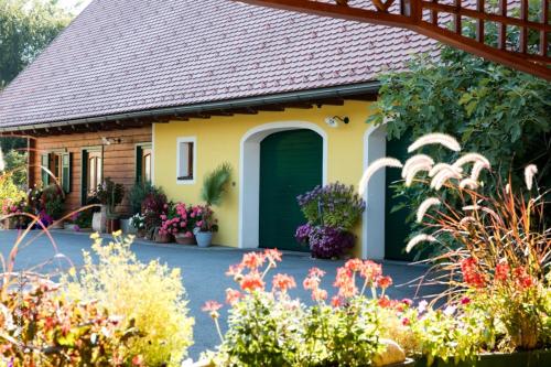 a house with a green door and some flowers at Weingut- Gästezimmer Marko in Leutschach