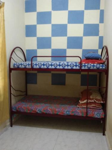 a bunk bed in a room with a wall at Zara Homestay in Machang