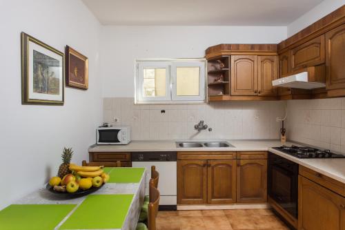 una cocina con una mesa con un bol de fruta. en Apartment Eleonora, en Dubrovnik