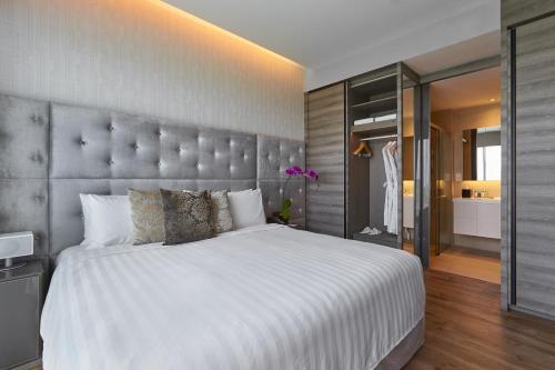 a bedroom with a large bed with a large headboard at Pan Pacific Serviced Suites Beach Road, Singapore in Singapore