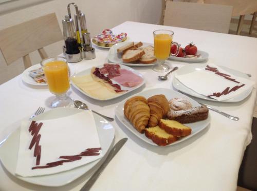 a table with plates of pastries and glasses of orange juice at Vehí in Cadaqués