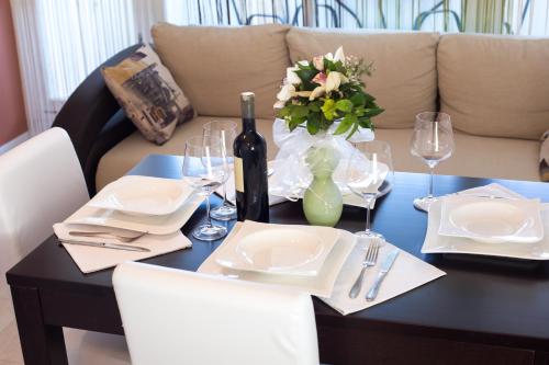 a table with a bottle of wine and a vase of flowers at Apartment Amalfi in Split