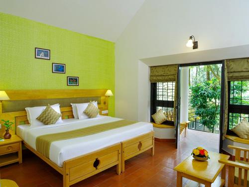um quarto com uma cama grande e paredes verdes em Hotel Treetop em Thekkady