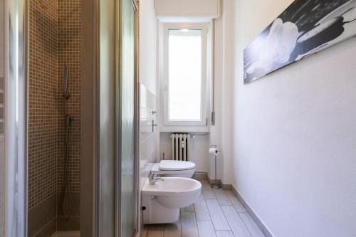 uma casa de banho com um WC, um lavatório e uma janela em Milanocity MICO MIART em Milão