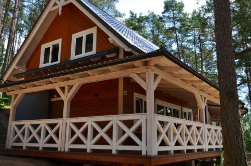 a cabin in the woods with a gambrel roof at Domki Kaszuby - jezioro las i zoo w Szarlocie in Kościerzyna
