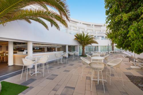 
a patio with chairs and tables in front of a building at Iberostar Selection Lanzarote Park in Playa Blanca
