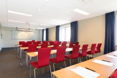 a classroom with desks and red chairs in a room at ProfilHotels President in Norrköping