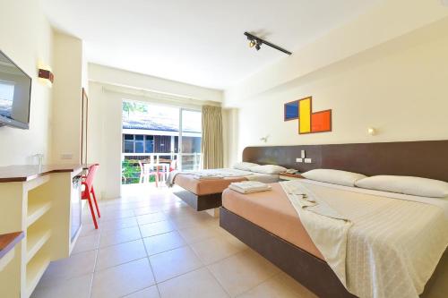 a hotel room with two beds and a television at Signature Boracay South Beach in Boracay