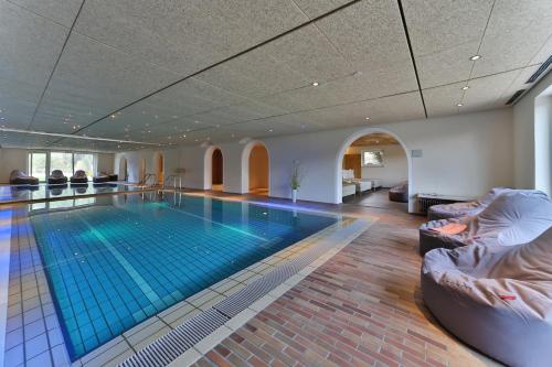 a swimming pool in a hotel room with a pool at Zedernhof Gesundheits- & Wellnesshotel in Stamsried