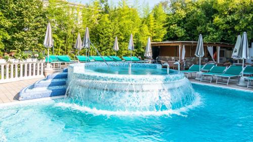 a swimming pool with a fountain in the middle at Hotel Smeraldo in Lazise