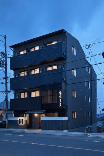 a black building with many windows on a street at Stay SAKURA Kyoto Kiyomizu Gojo in Kyoto