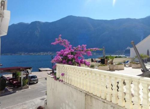 a white railing with pink flowers on a balcony at Apartments Vila Marija in Kotor