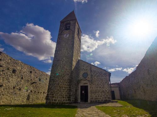 a tall tower with a clock on the side of a building at Family Apartment Rihter in Črni Kal