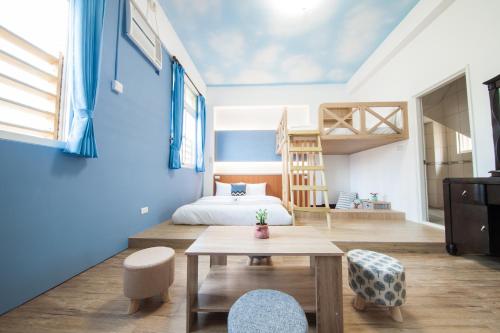 um quarto com paredes azuis, uma cama e uma mesa em D.C. Inn em Magong