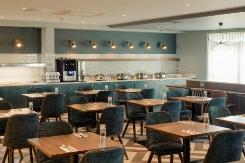 a restaurant with tables and chairs and a counter at The Hoban Hotel Kilkenny in Kilkenny