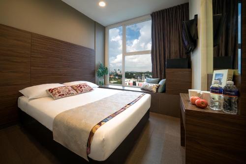 a bedroom with a large bed and a large window at Value Hotel Thomson in Singapore