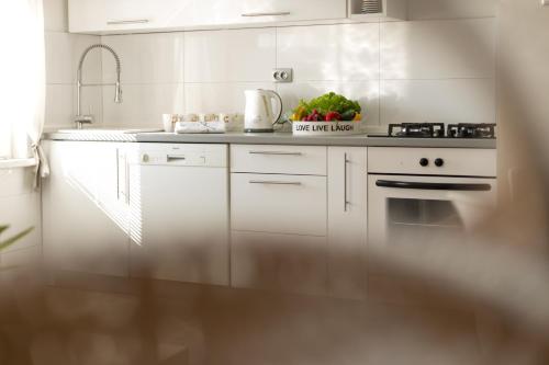 a white kitchen with a sink and a stove at Apartments Gacka Valley in Otočac