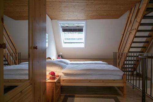 1 Schlafzimmer mit 2 Betten in einem Zimmer mit Treppen in der Unterkunft Ferienhaus "An der Bäke" in Bad Zwischenahn