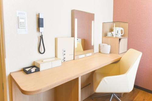 a desk in a room with a white chair at Hotel Gracery Sapporo in Sapporo
