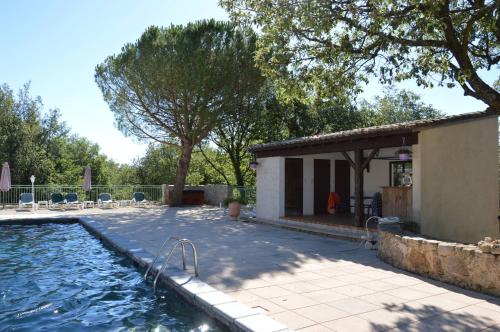 una casa con piscina al lado de un edificio en Les Rouges Gorges du Domaine du Moulin 14, en Étables