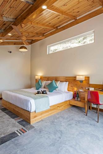 a bedroom with a large bed and a desk at Rakkh Resort, a member of Radisson Individuals Retreats in Pālampur