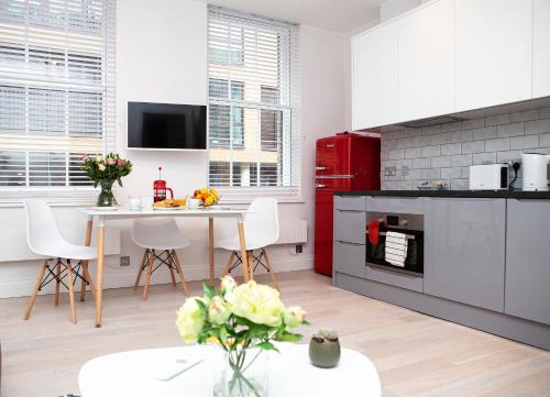 a kitchen with a red refrigerator and a table at Soho Suites by Indigo Flats in London