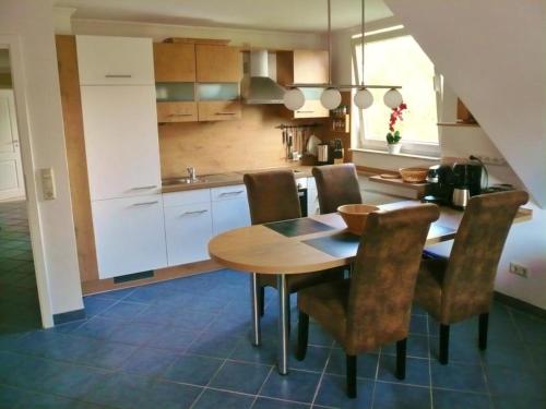 a kitchen with a wooden dining table and chairs at Fewo C am Kurpark mit MeineCardPlus in Willingen