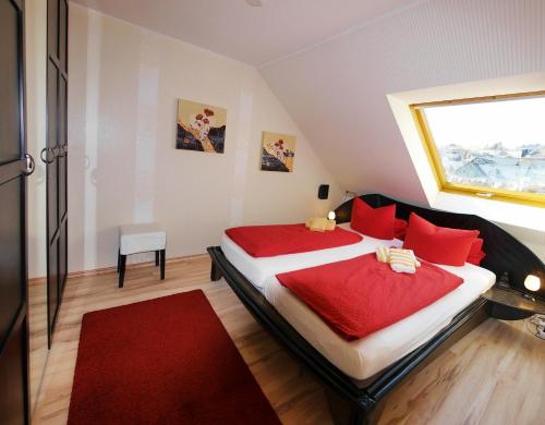 ヴィリンゲンにあるFewo C am Kurpark mit MeineCardPlusのベッドルーム1室(赤い枕のベッド2台、窓付)