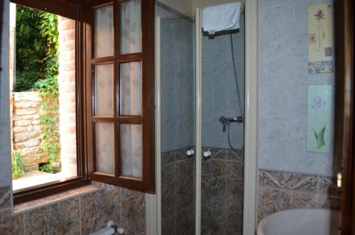 a bathroom with a shower with a tub and a sink at Casa Rural El Bellucu in Cangas de Onís