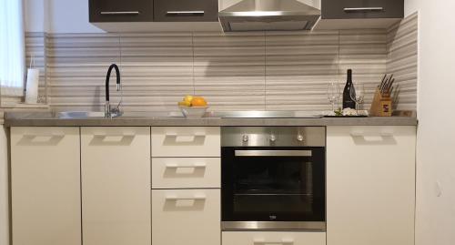 a kitchen with white cabinets and an oven and a sink at Lovely apartment in Pomer in Pomer