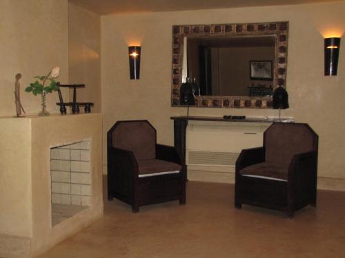 a living room with two chairs and a fireplace at Dar Sabra in Marrakech