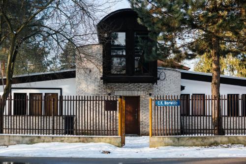 a white building with a gate and a fence at Villa Lulu Piaseczno in Piaseczno