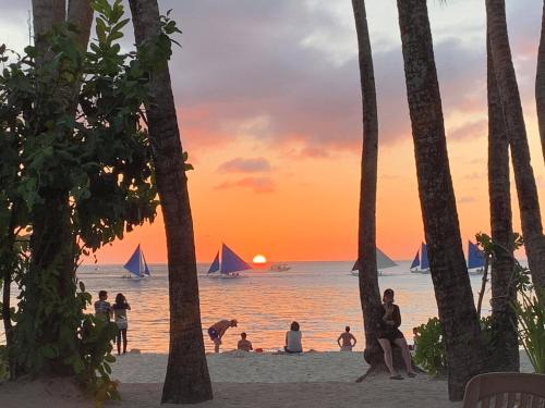 a beach with palm trees and palm trees at Hey Jude South Beach in Boracay