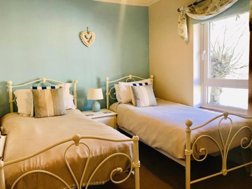 two beds sitting next to each other in a bedroom at Southgrove View, Family Holiday Cottage in Ventnor