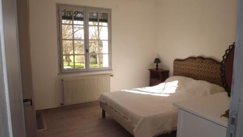 a bedroom with a bed and a window at L'Oustau in Cavaillon