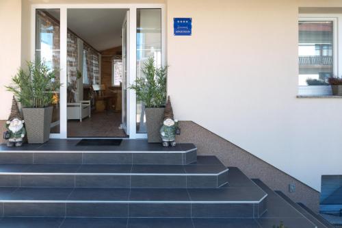 a group of stairs in a building with potted plants at Apartments Gacka Valley in Otočac